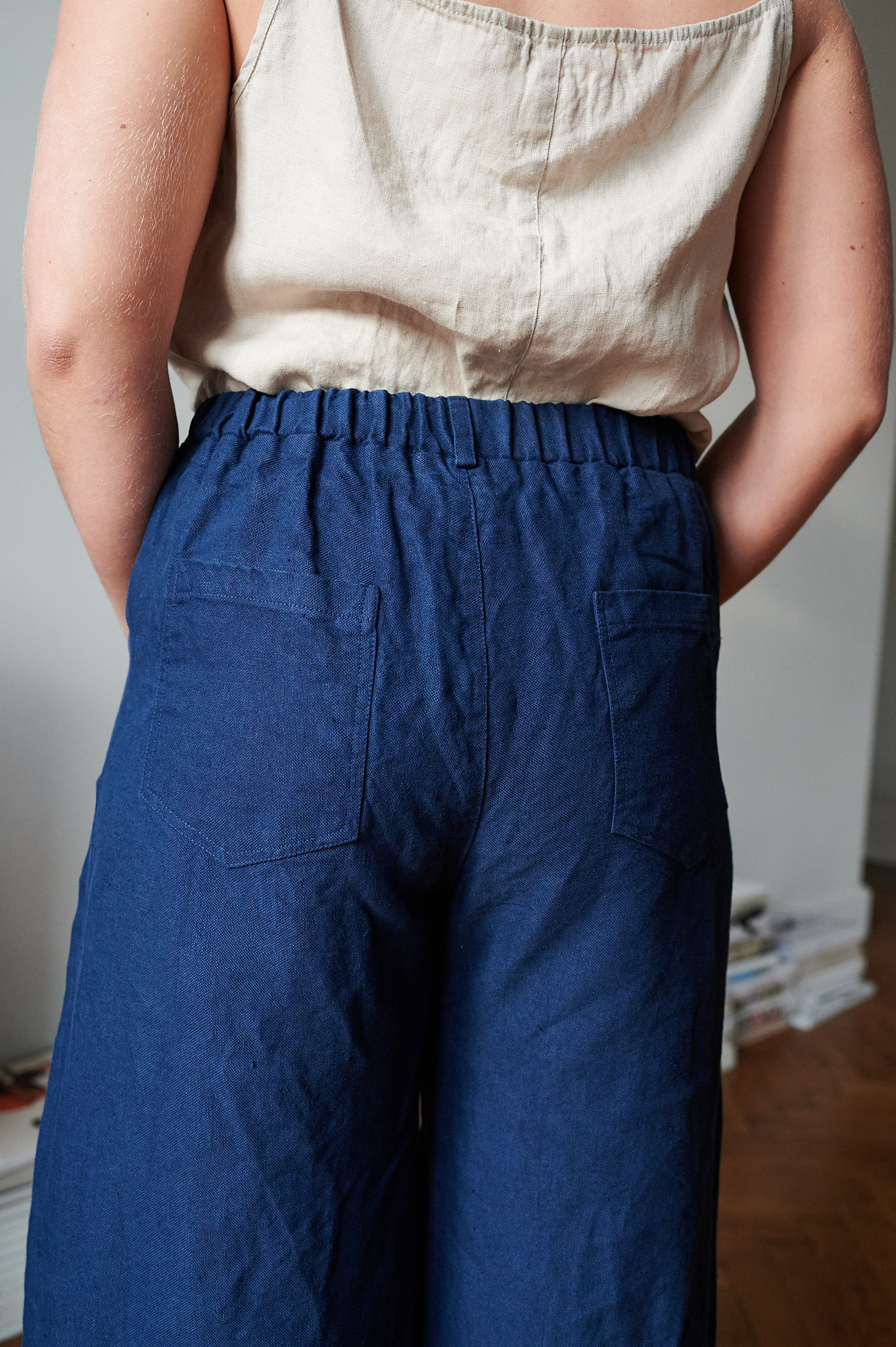 The back pockets of navy blue heavy linen pants