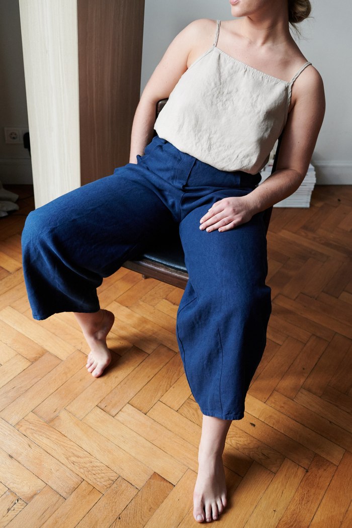 A woman sitting in navy blue heavy linen pants