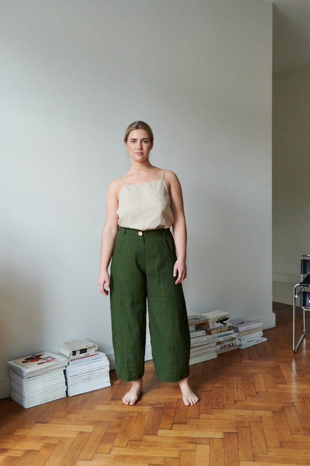 A woman in barrel leg heavy linen trousers in green