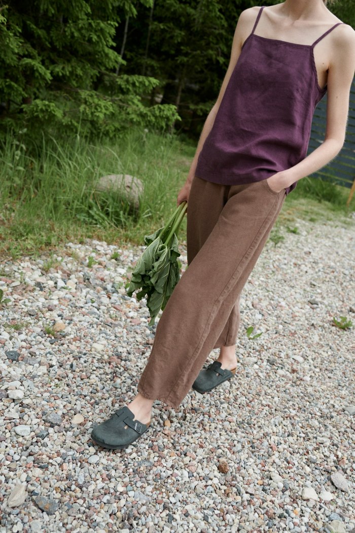 Woman walking in barrel leg slightly cropped linen trousers with pockets