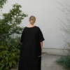 Back of a model in a black oversized linen dress
