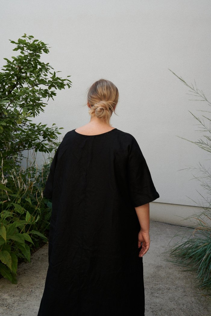 A black oversized linen dress with flared wide sleeves