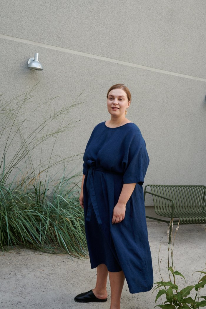 Model in a mid-length oversized linen dress with flared sleeves