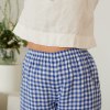 The elastic waistband of natural linen trousers in blue gingham