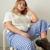 A woman wearing relaxed fit linen trousers in blue gingham