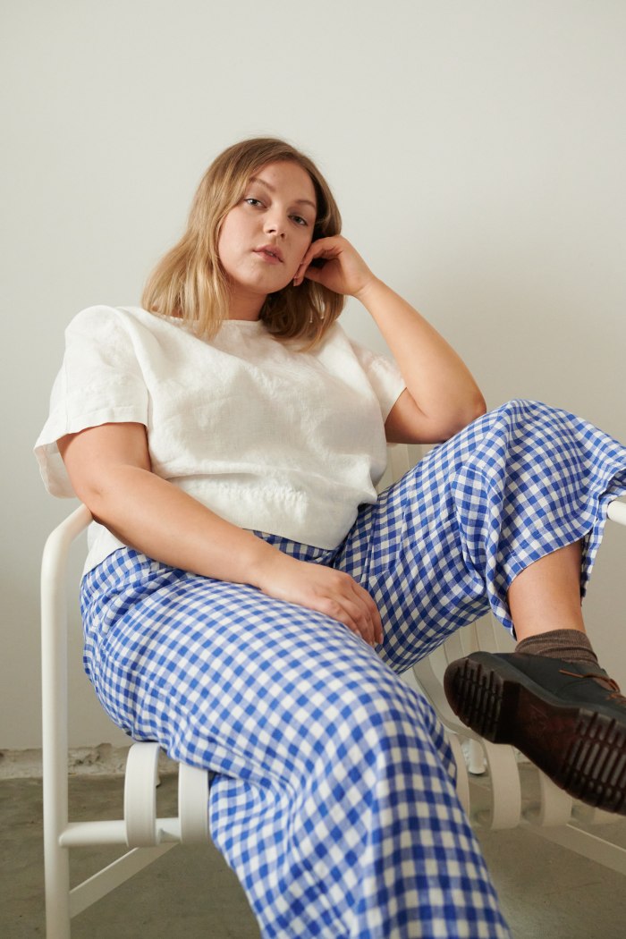 A woman wearing relaxed fit linen trousers in blue gingham