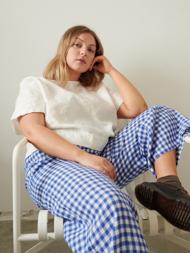 A woman wearing relaxed fit linen trousers in blue gingham