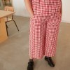 Relaxed red gingham linen trousers on a model