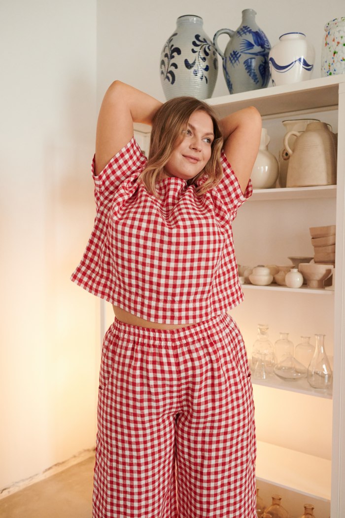 A model wearing wide leg red gingham trousers and a matching top
