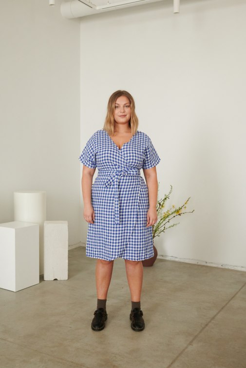 a woman in blue gingham wrap dress