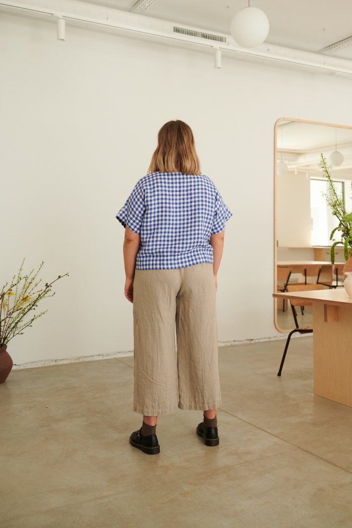 A woman wearing boxy oversized linen top in blue gingham