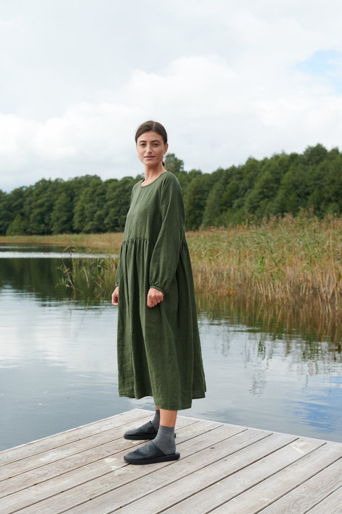 Woman in dark green oversized linen dress