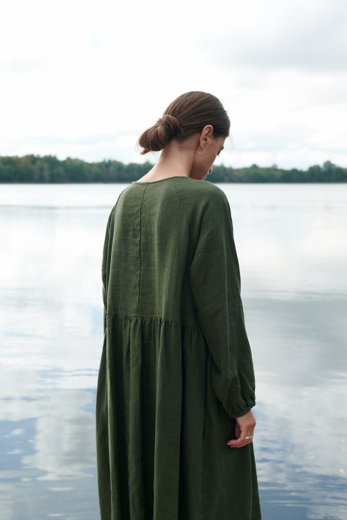 A woman is wearing a long sleeve linen smock dress