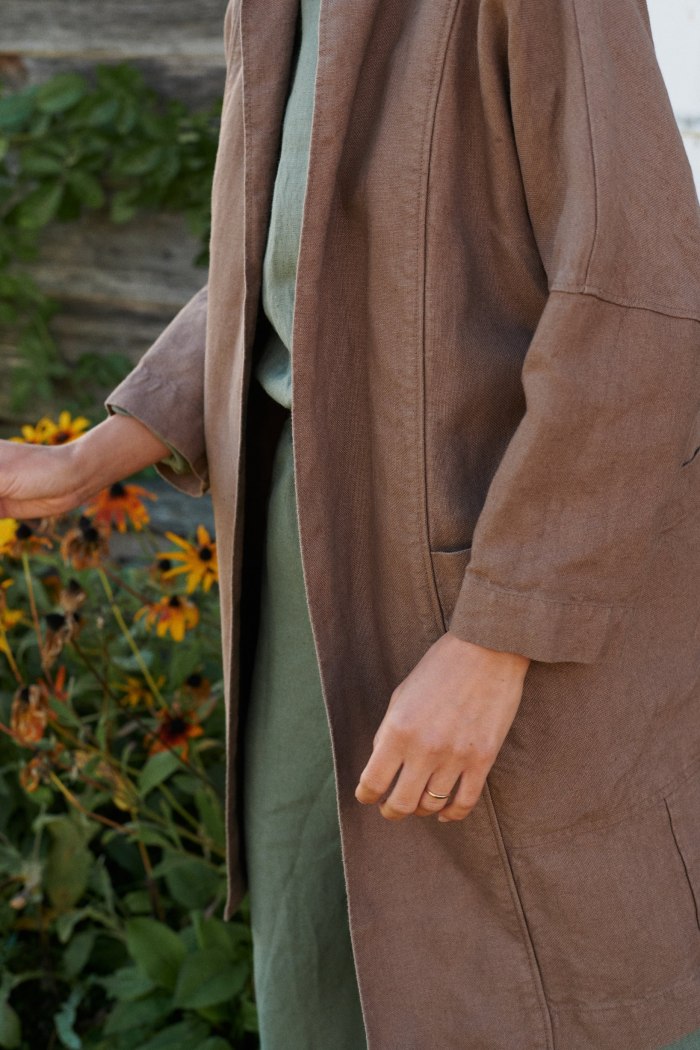 Model wearing an oversized heavy linen jacket with dropped sleeves and deep pockets