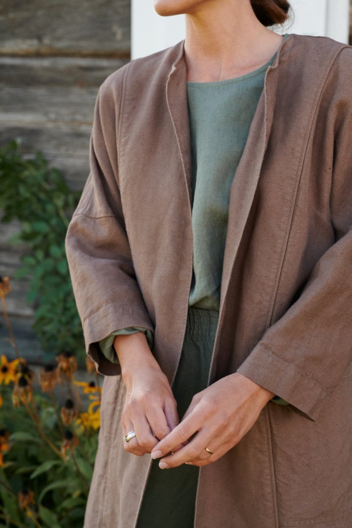 Model wearing a heavy linen jacket with high neckline and three quarter sleeves