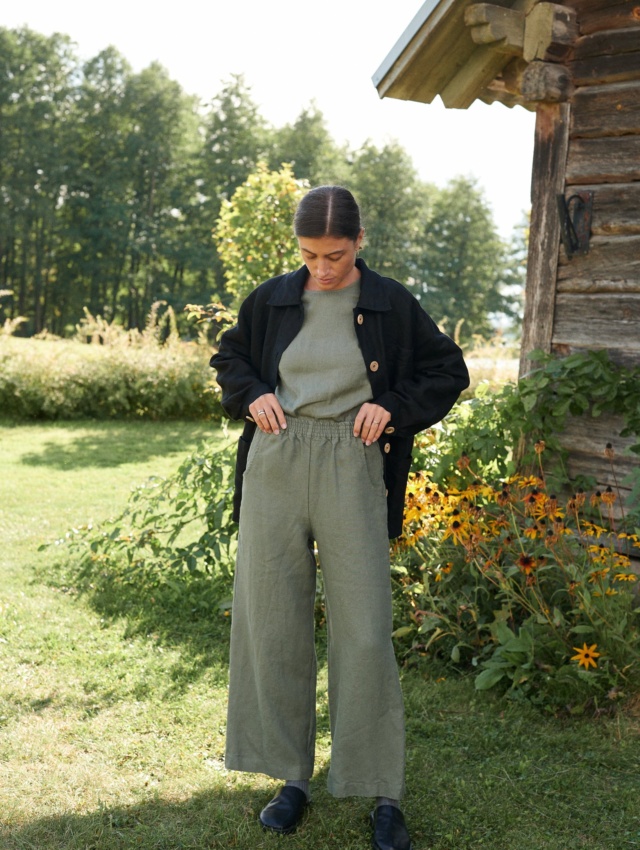 Woman wearing muted green wide leg linen trousers