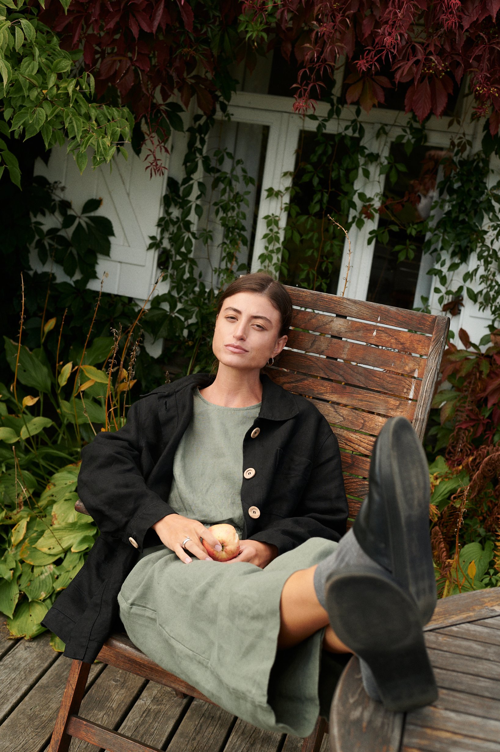 A woman sitting in pine green relaxed fit trousers