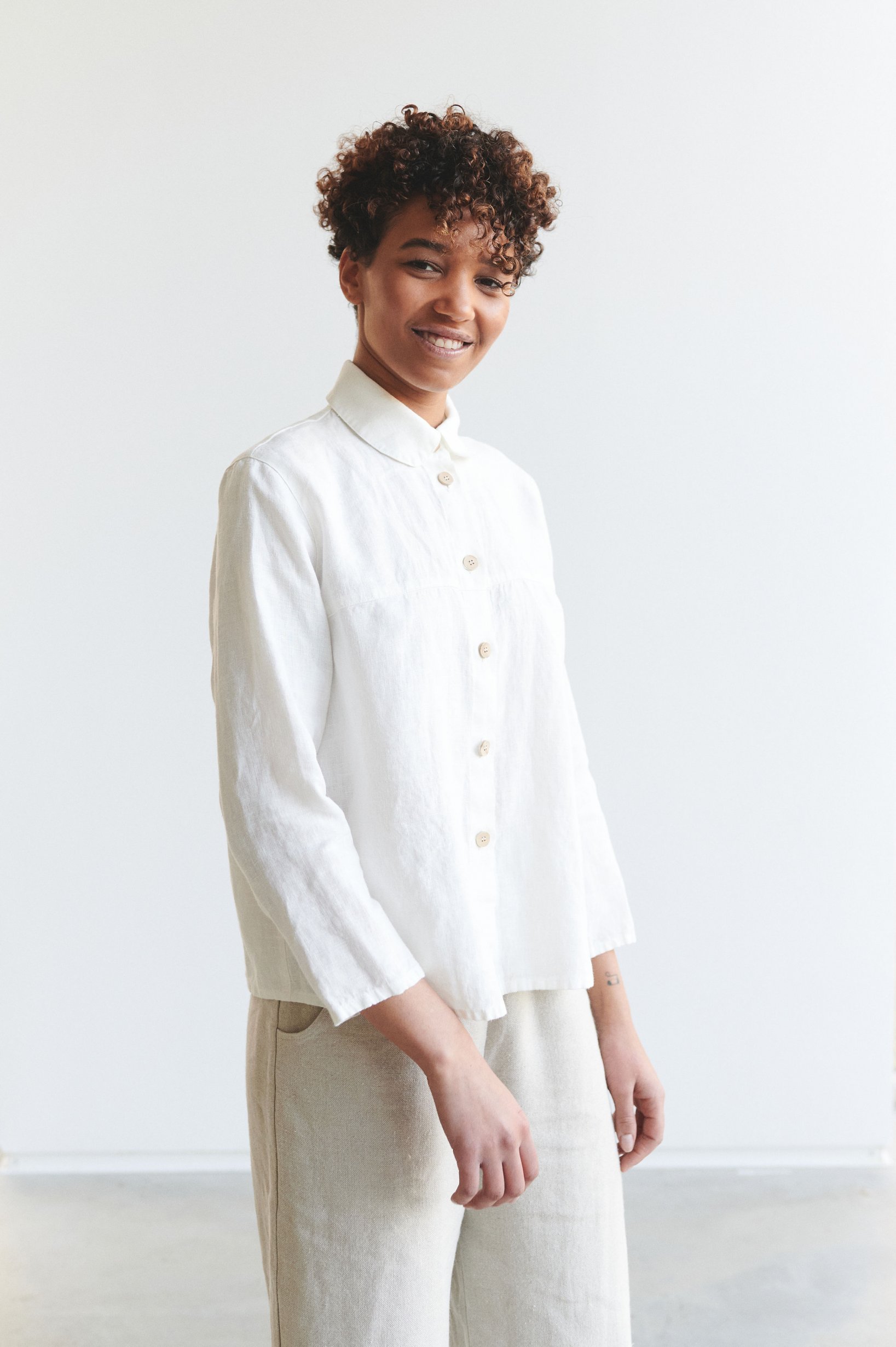 Model wearing white linen button down shirt
