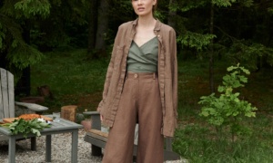 A woman standing in brown wide leg heavy linen pants