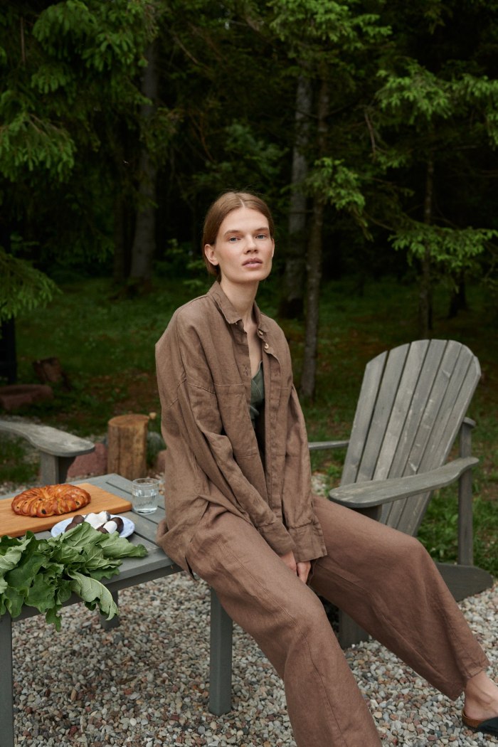 A woman in matching brown heavy linen trousers and a shirt