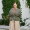 Woman in a heavy linen relaxed fit green jacket tied with a matching belt