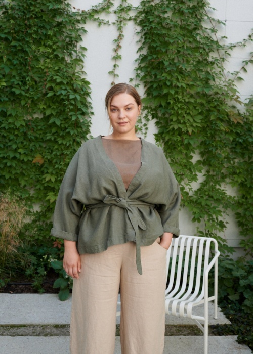 Woman wearing a pine green heavy-weight linen jacket tied with s belt