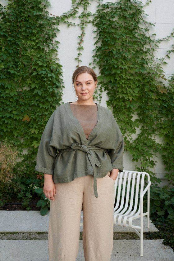 Woman wearing a pine green heavy-weight linen jacket tied with s belt