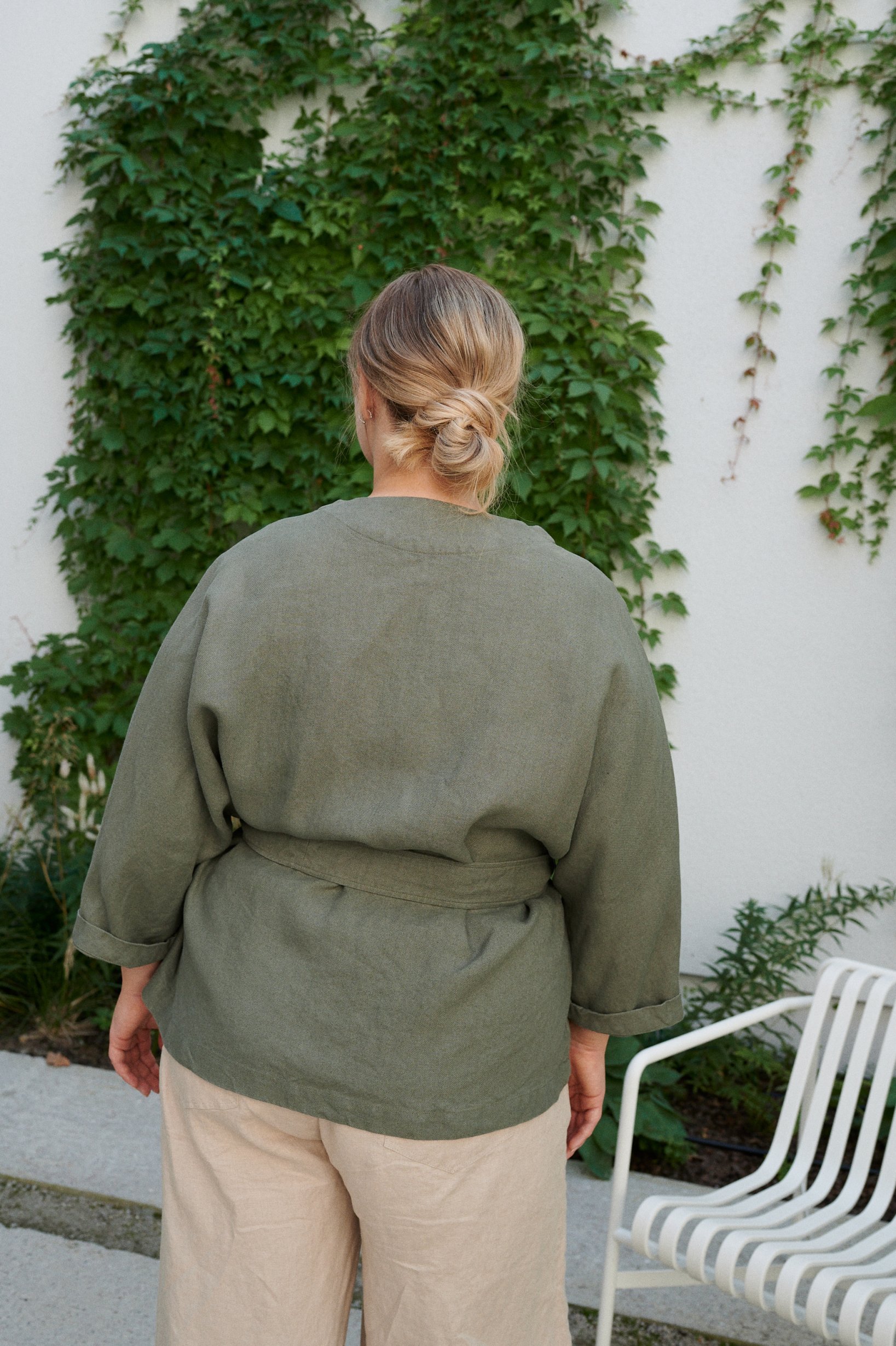 Back of a model wearing a loose-fitting kimono inspired linen jacket