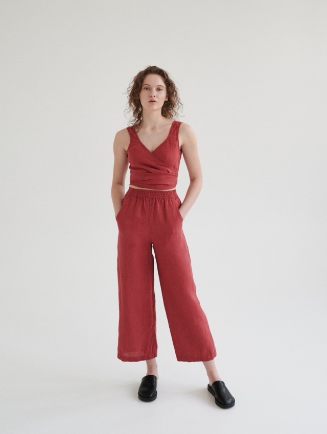 Woman wearing high-waisted linen pants with pockets paired with a matching linen wrap top