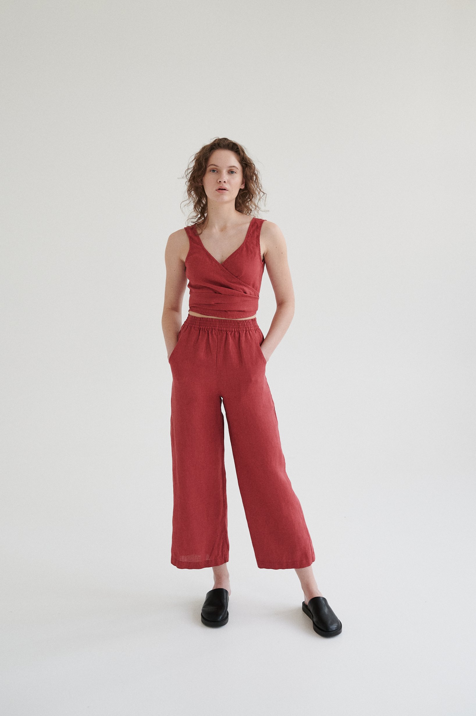 Woman wearing high-waisted linen pants with pockets paired with a matching linen wrap top