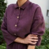 A button-down linen jumpsuit with a dress shirt collar and wooden buttons