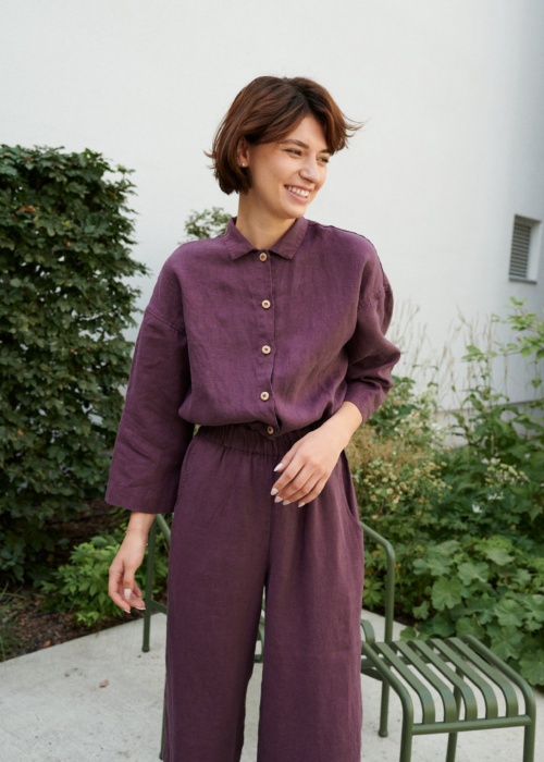 An eggplant violet button-down linen jumpsuit with an elasticated waistband