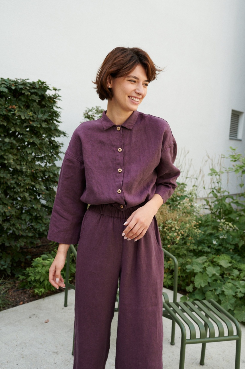 An eggplant violet button-down linen jumpsuit with an elasticated waistband