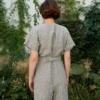 Back of a model in a relaxed fit linen jumpsuit with a belt