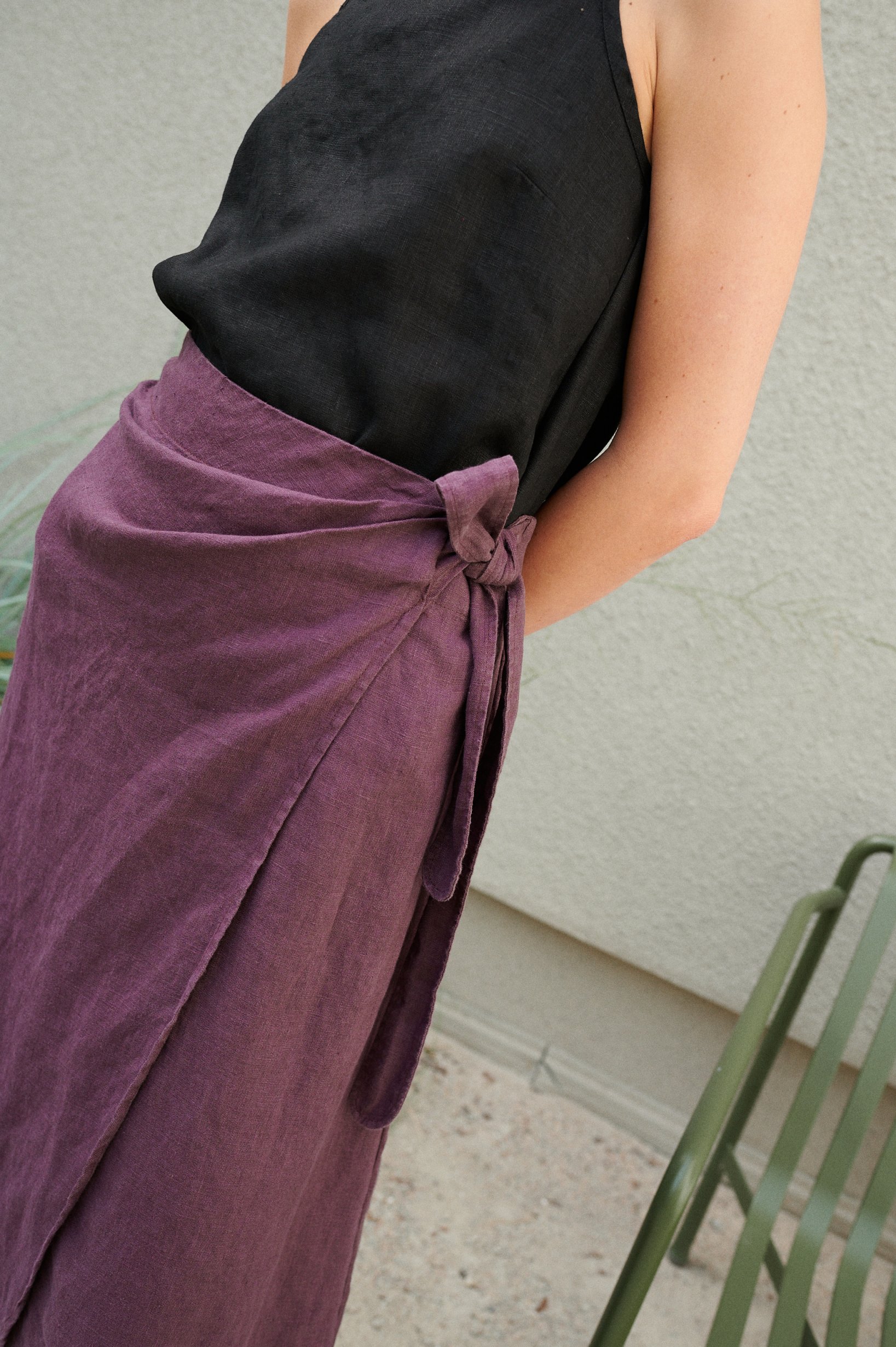 Details of an eggplant violet linen skirt with an elasticated waist and a tie