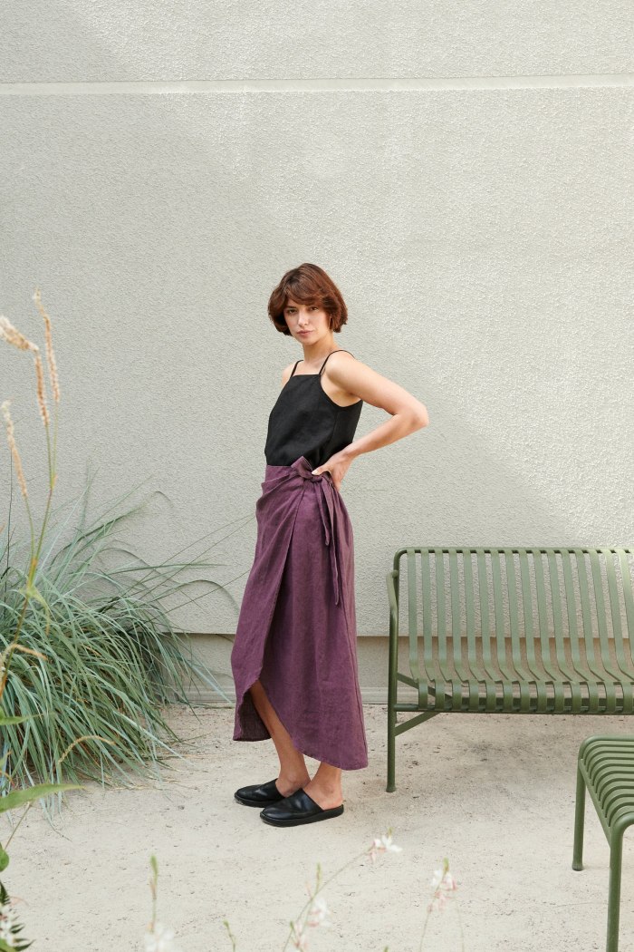 Woman wearing a long wrap linen skirt and a black linen summer top