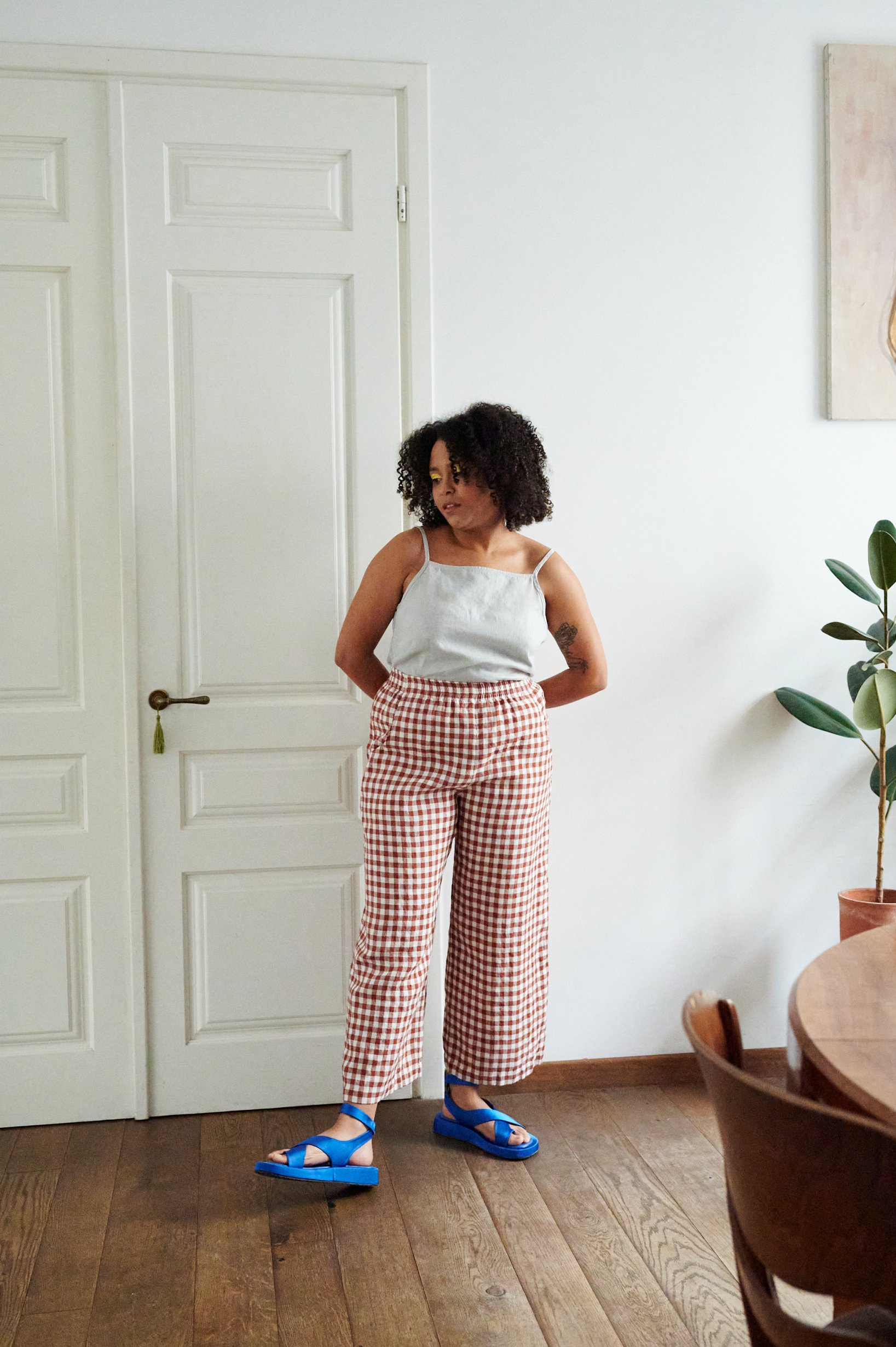 A model in brown gingham relaxed wide leg linen pants
