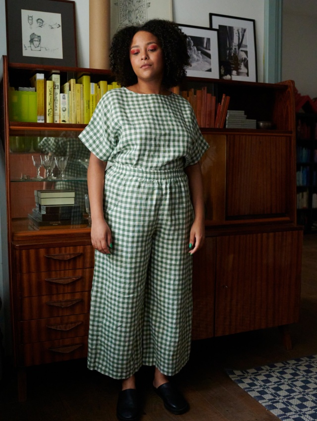 A woman wearing high elasticated waist linen trousers in green gingham