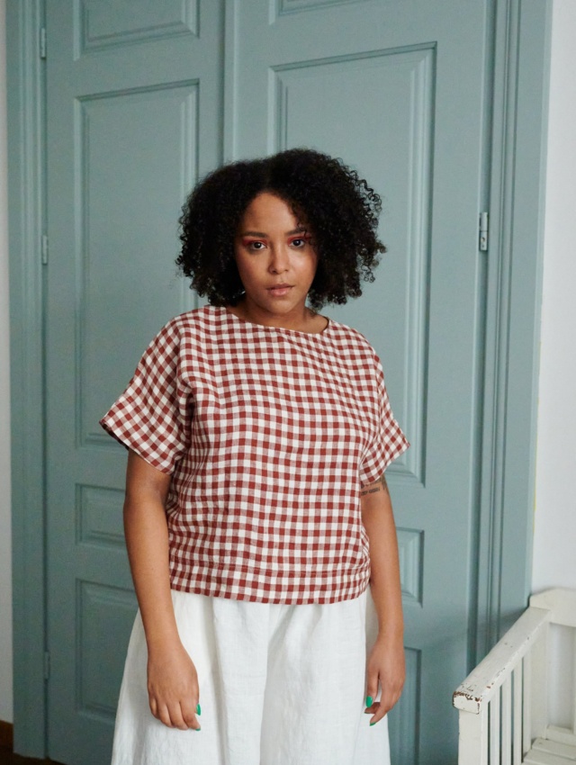 A model in straight cut short sleeve linen top in terracotta gingham