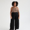Model in wide-leg black linen trousers and a sleeveless linen top