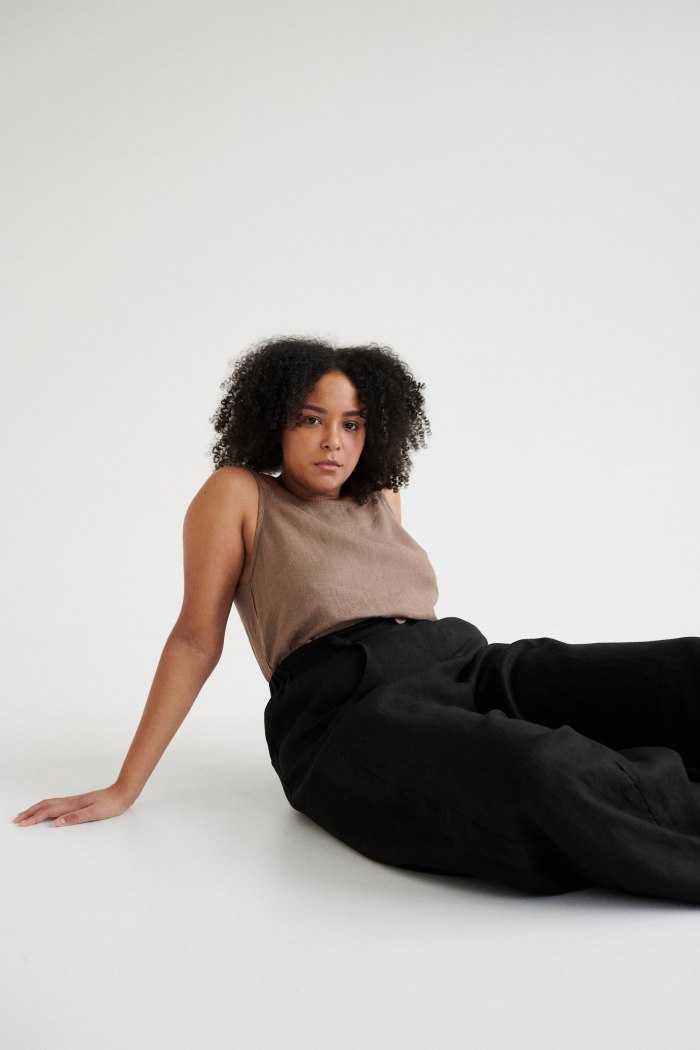 A light brown linen summer top and black barrel leg linen trousers outfit