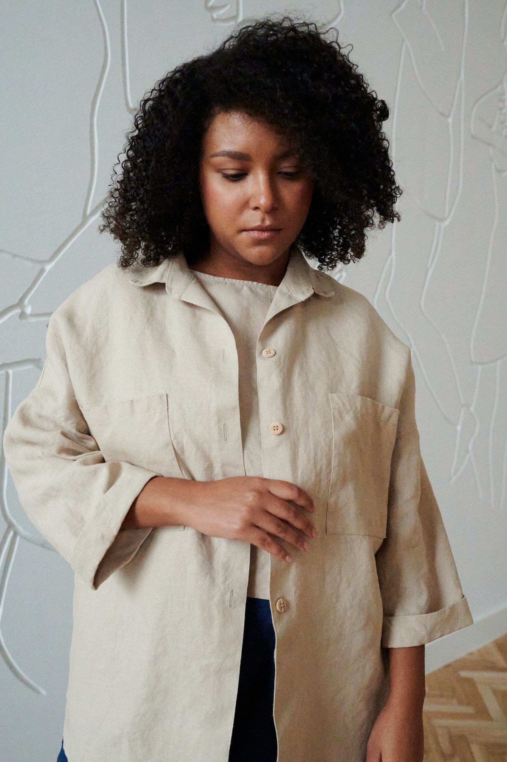 A loose-fitting button down linen shirt with three-quarter rolled up sleeves and wooden buttons