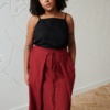 Model in a long red linen skirt and a black linen top outfit