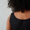 Back of a sleeveless linen top with a round neckline and wide straps