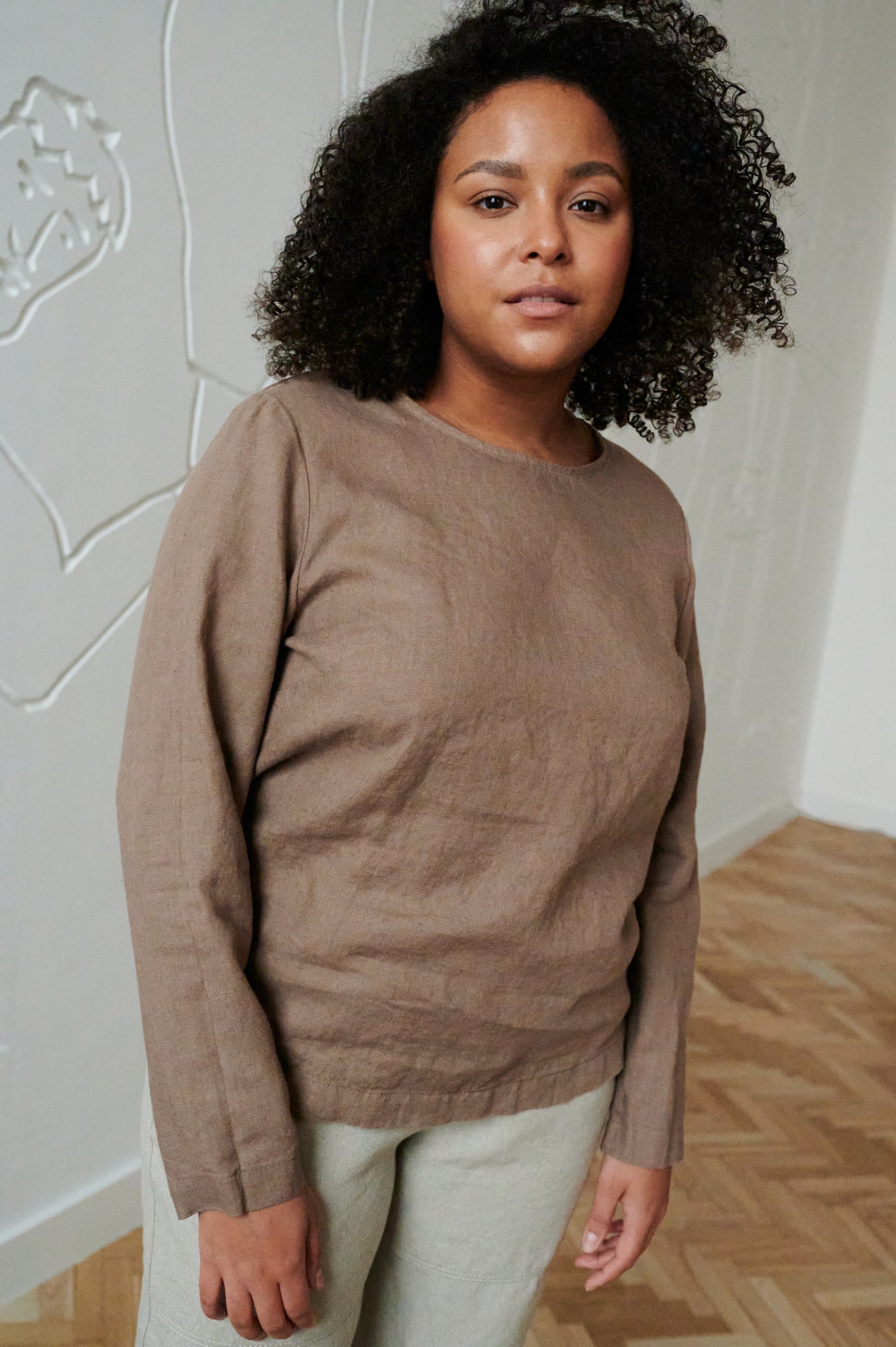 Model wearing a straight cut long sleeve linen blouse in cacao color