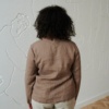 Back of a model in a cacao long sleeve straight cut linen blouse