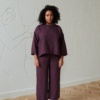 A model in violet linen oversized tunic and matching trousers