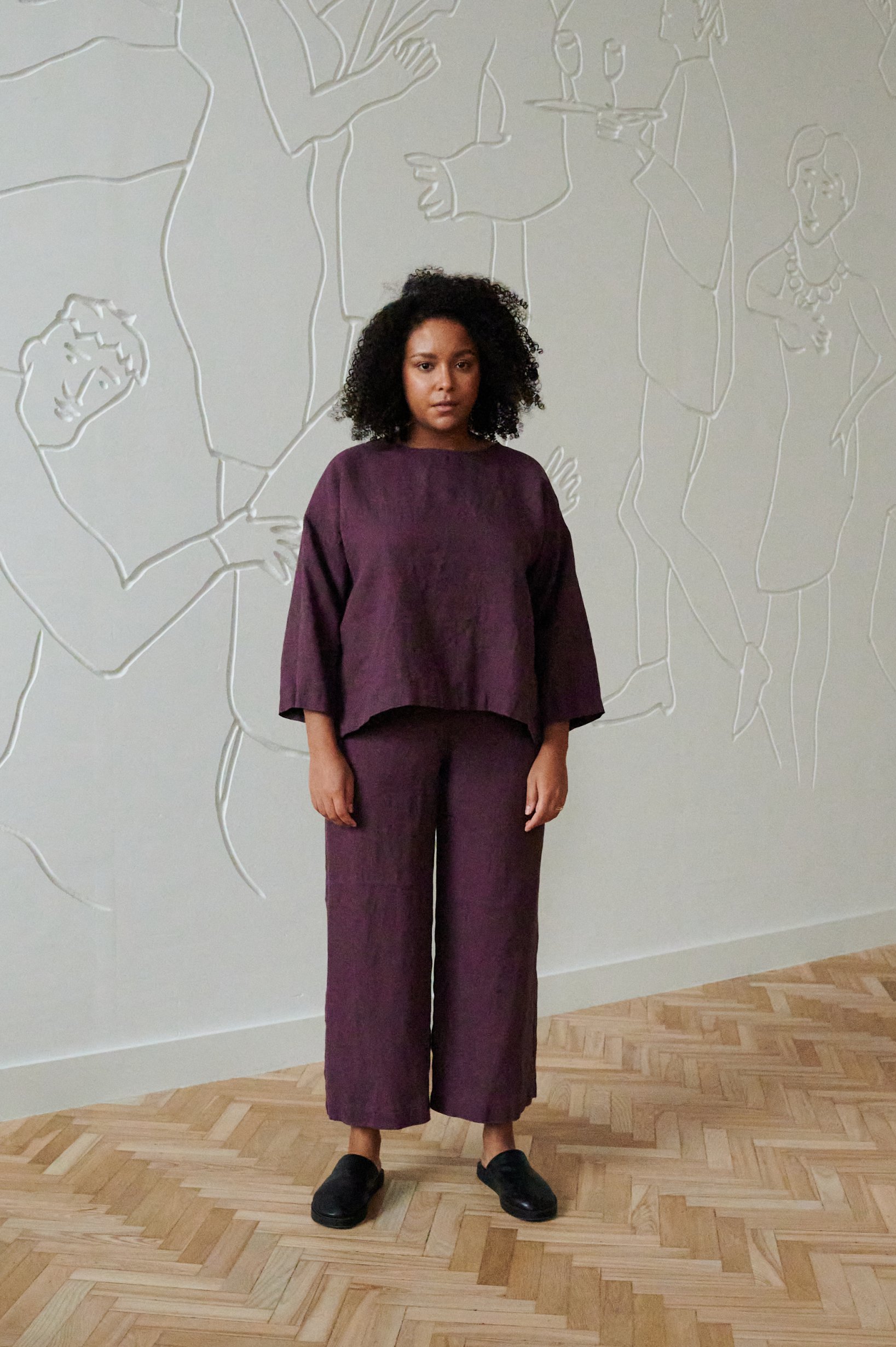A model in violet linen oversized tunic and matching trousers