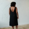 A relaxed fit black linen dress with a deep open back