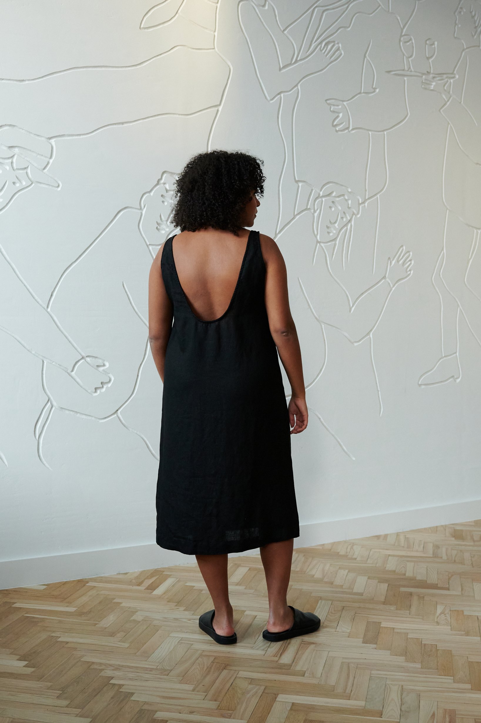 A relaxed fit black linen dress with a deep open back